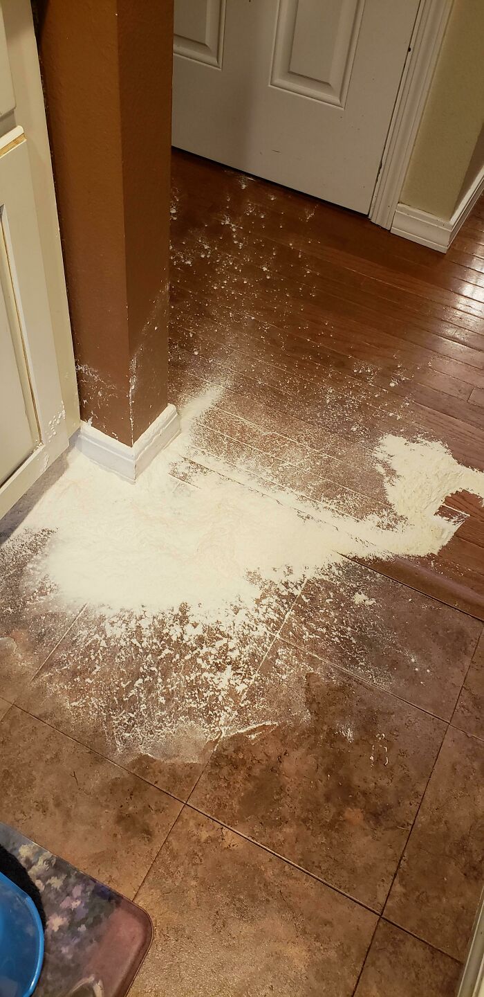 A floor covered in a white powdery mess, likely flour or sugar, a clear sign of mischievous kids.