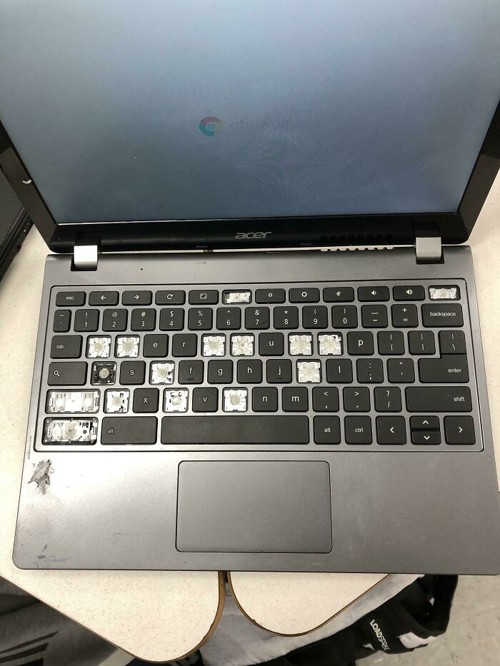 An open Acer laptop with many keyboard keys missing, a testament to mischievous kids.