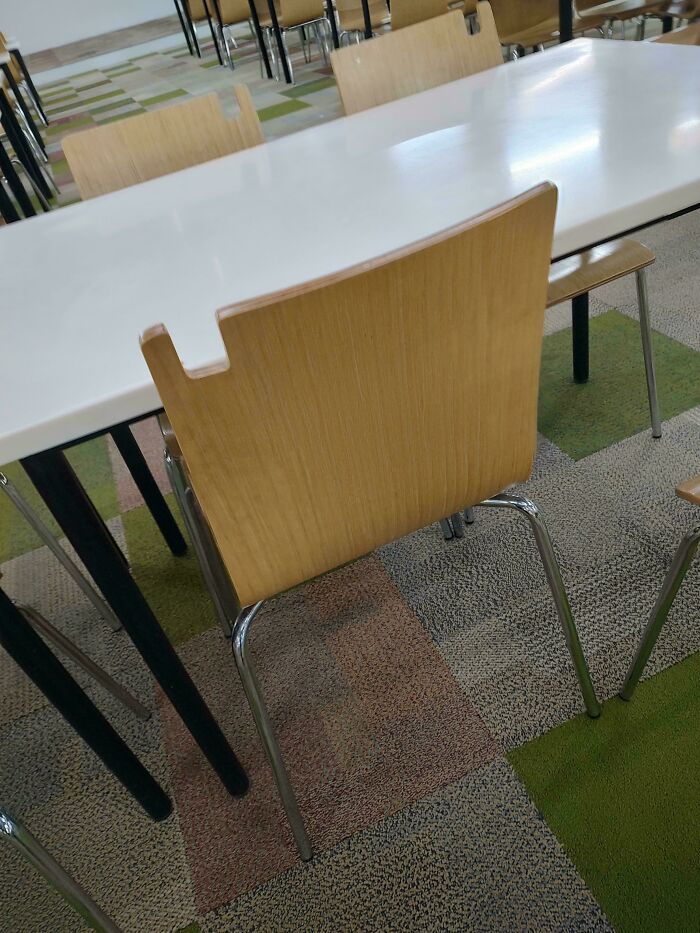 A wooden chair with a white table in a room with a patterned carpet, highlighting practical product designs.