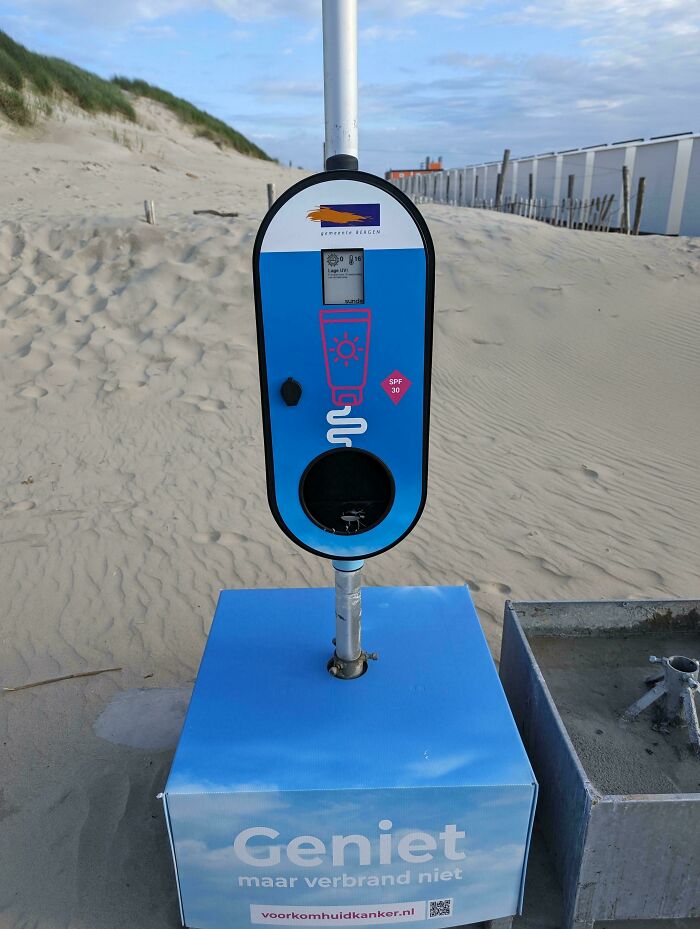 A sunscreen dispenser on a sandy beach, offering SPF 30, a brilliantly practical product design for sun protection.