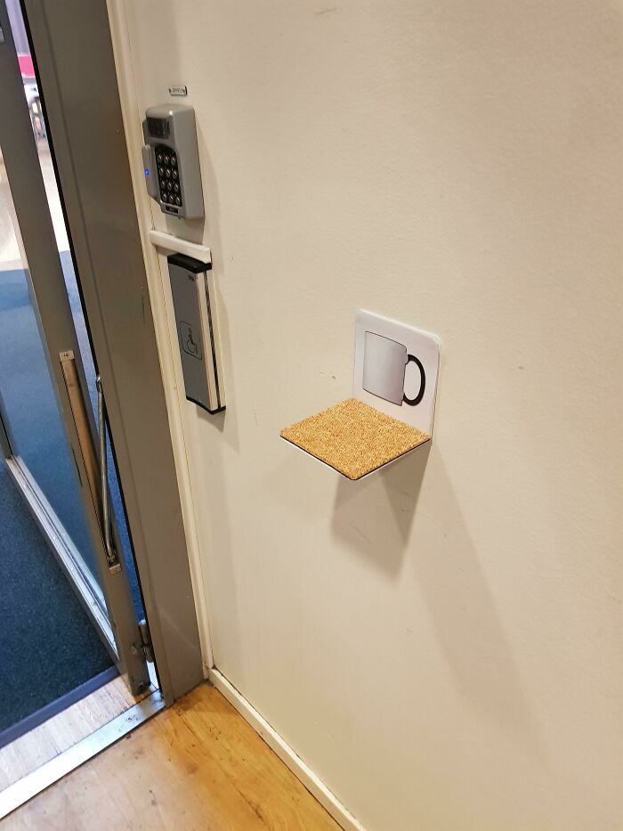 A small, practical shelf with a cup icon on a wall next to a door, one of many brilliant product designs.