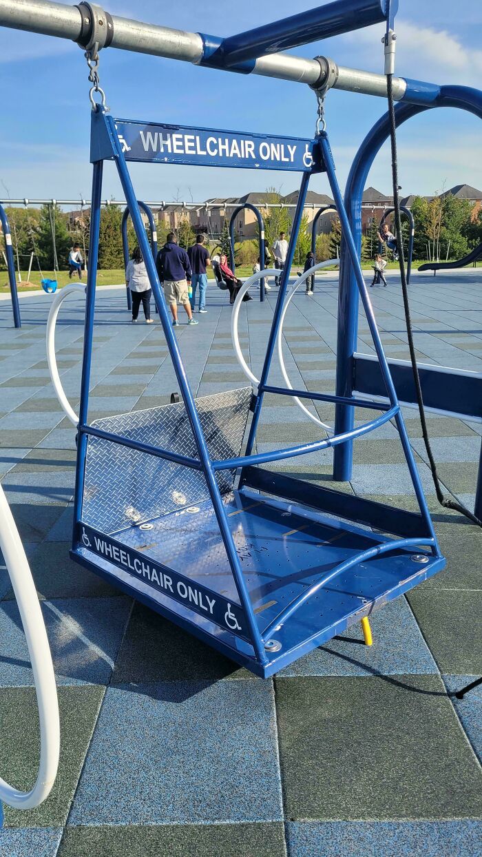 A blue wheelchair-accessible swing at a park, a brilliant product design ensuring inclusivity for all children.