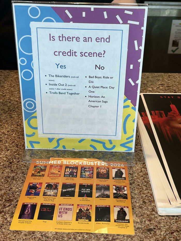 A sign asking Is there an end credit scene? with movie titles listed, a practical product design for moviegoers.