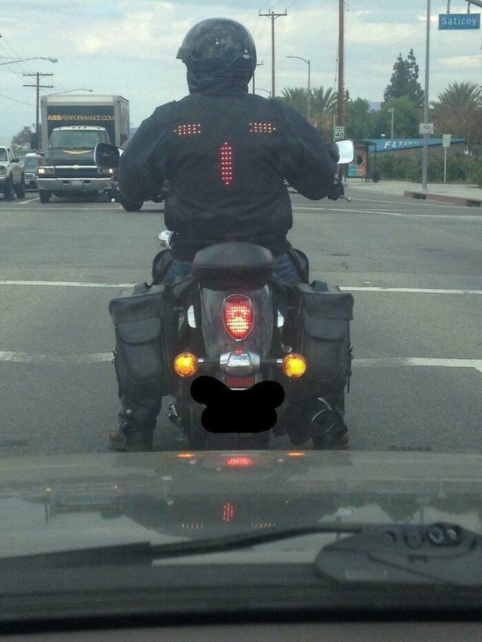 A motorcyclist wearing a jacket with LED lights, a brilliant example of practical product designs for safety.