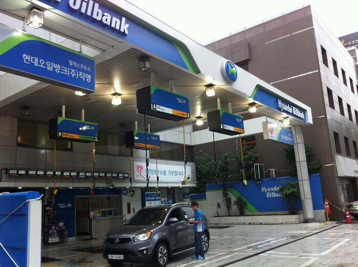 A Hyundai Oilbank gas station with a car fueling, showcasing practical product designs in urban infrastructure.