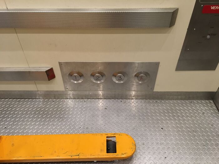 Large, clearly labeled elevator buttons in a cargo lift, a practical product design for industrial use.
