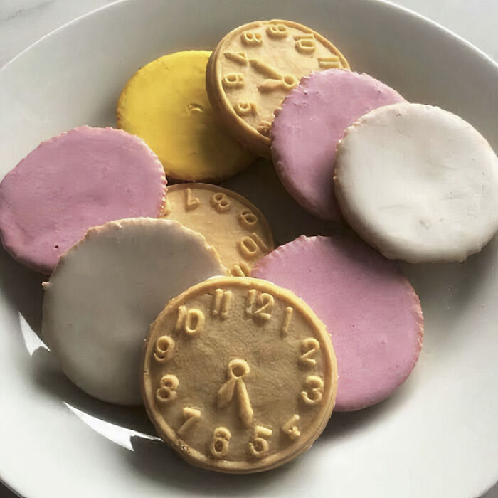 A pile of colorful iced biscuits, including some shaped like clocks, bringing back nostalgic Aussie memories of childhood.