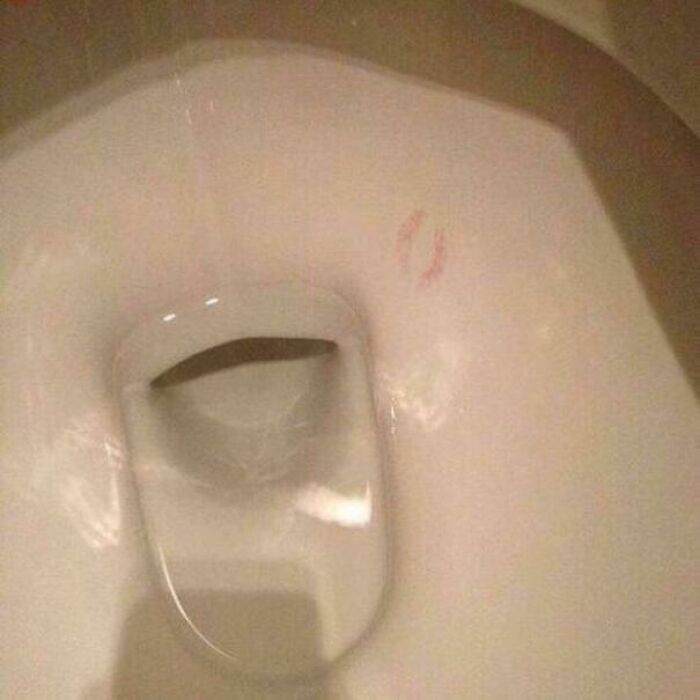 A toilet bowl with lipstick marks inside, an unhinged image that makes you go 'hmmm'.