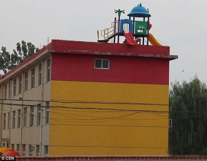 A rooftop playground on a red and yellow building, one of many unhinged images.