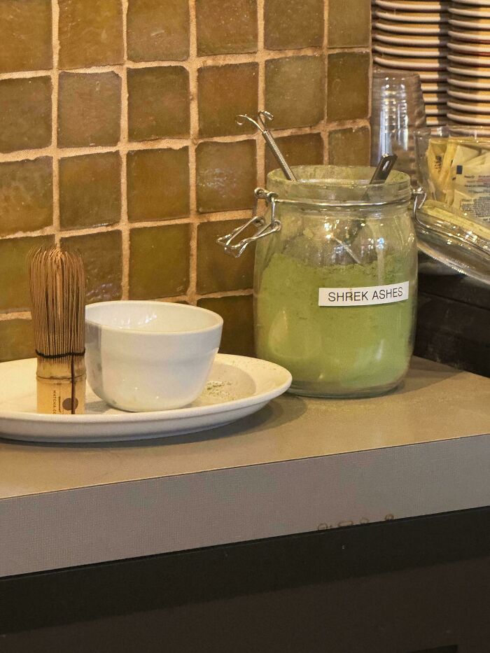 A jar labeled 'Shrek Ashes' filled with green powder next to a matcha whisk and bowl, creating unhinged imagery.