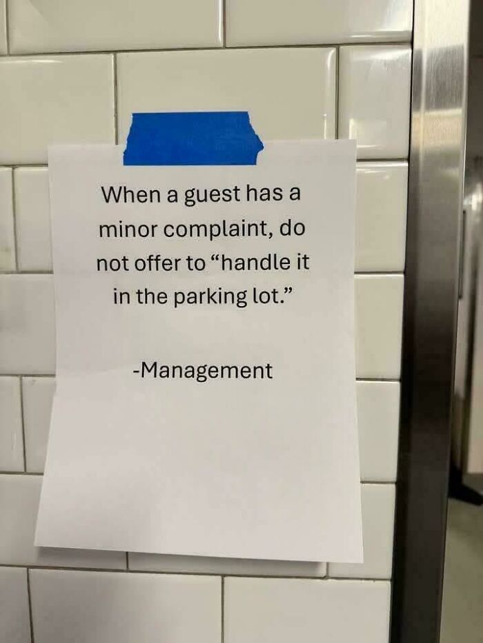 An unhinged note from management on a tiled wall, stating not to 'handle' guest complaints in the parking lot.