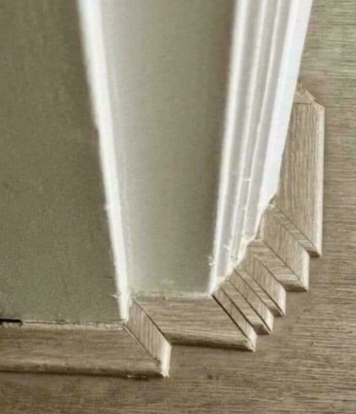 A poorly installed door frame with unhinged images of uneven cuts, showing a construction fail.