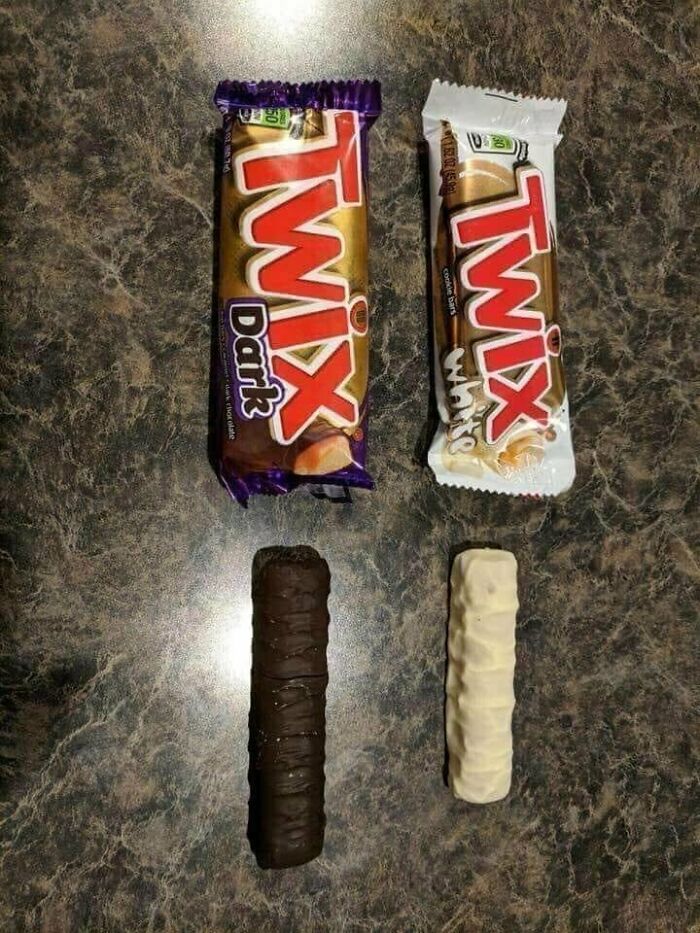 Two unwrapped Twix bars, one dark and one white, lie next to their wrappers on a dark surface, part of a collection of unhinged images.