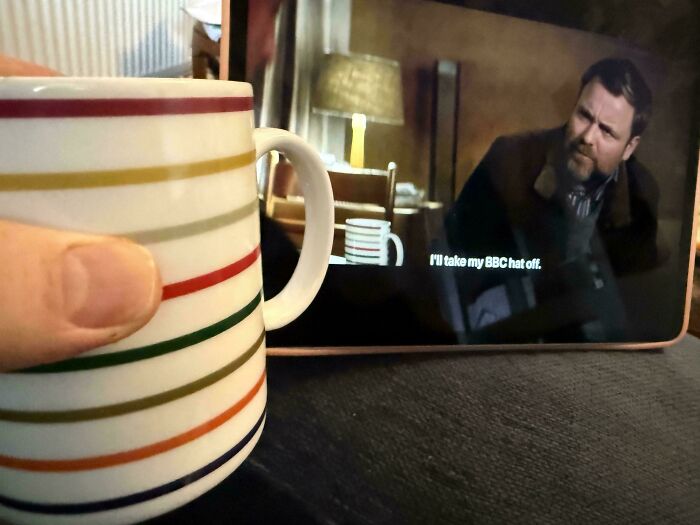 A striped mug perfectly aligning with the on-screen mug in a TV show, amazing times something synced just right.