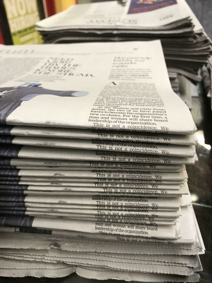 A stack of newspapers with the repeated phrase This is not a coincidence printed down the side, an amazing example of something synced just right.