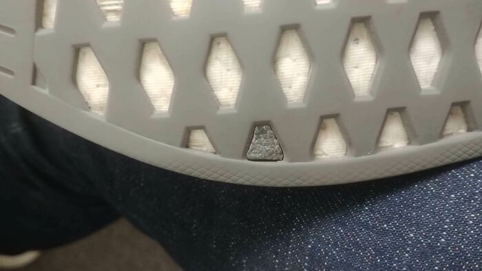 The sole of a shoe with a small, triangular rock perfectly embedded in one of its grooves, an amazing something Synced Just Right.
