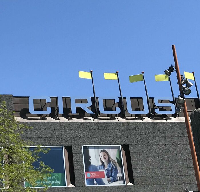 The word CIRCUS atop a building, with yellow flags synced against a clear blue sky, creating a vibrant scene.