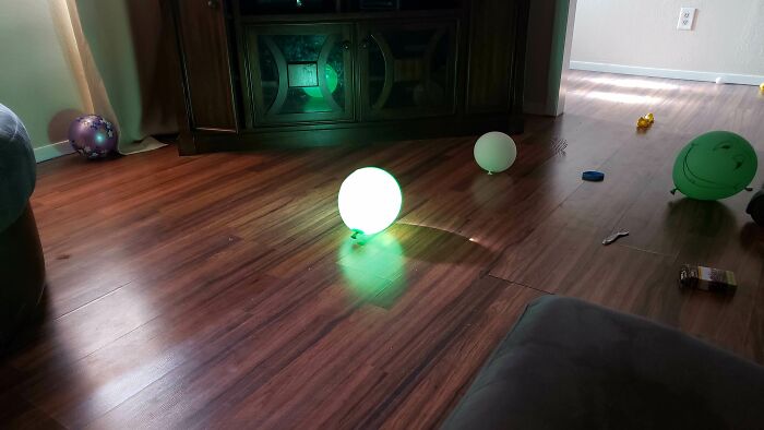 A glowing balloon is perfectly synced to light up a dark wooden floor, creating amazing times.