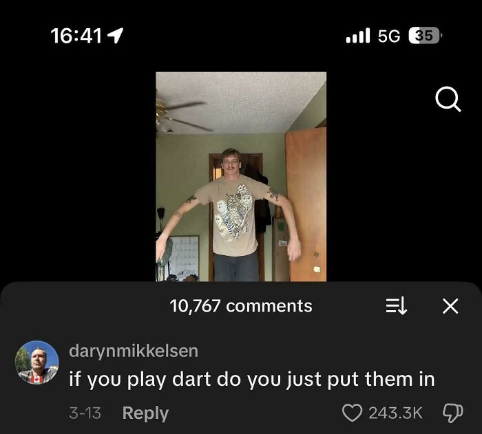 A man with long arms and a humorous comment section asking if he plays darts by just putting them in, from a video.