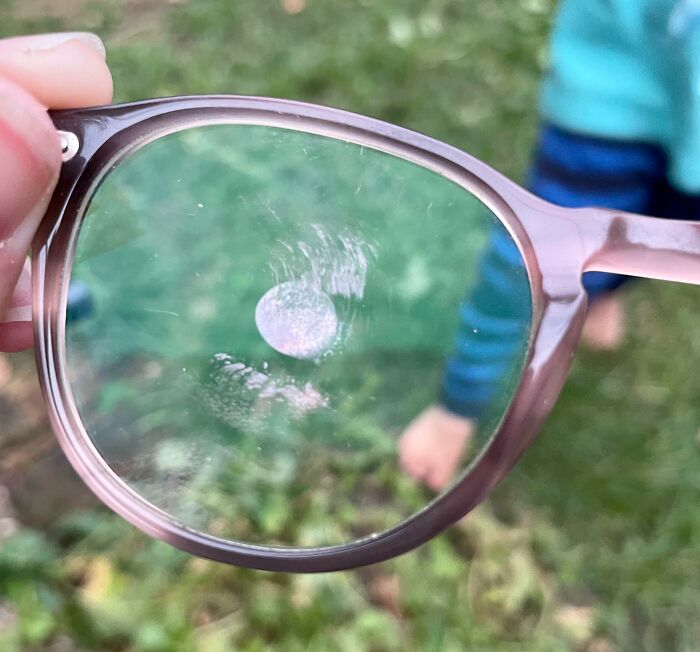 A pair of glasses with a sticky fingerprint on the lens, a common result of mischievous kids.