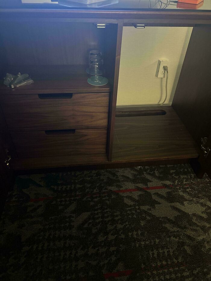 An open hotel cabinet with drawers and a charging area, showing products and services getting worse and more expensive.