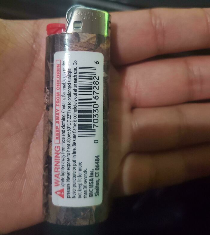 A hand holding a BIC lighter with a camouflage design, illustrating products and services getting worse and more expensive.