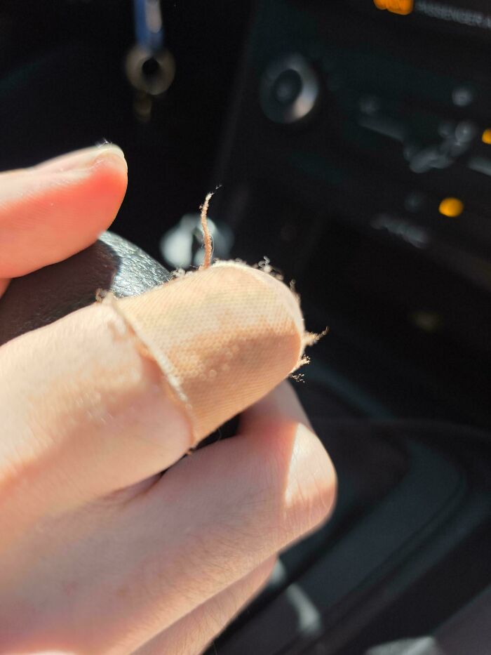 A finger with a small, worn bandage. It represents products and services getting worse and more expensive.