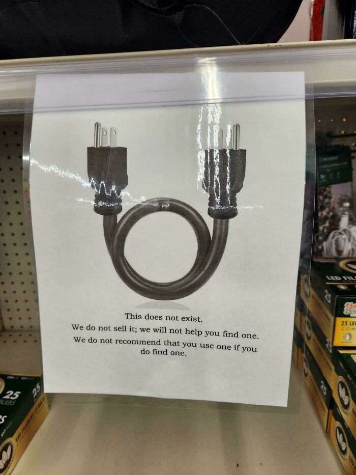 A chaotic sign in a store displays a looped power cord, stating This does not exist, questioning reality.