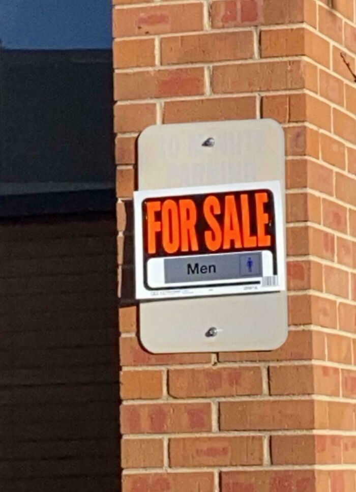 A chaotic sign on a brick wall advertises a For Sale sign, with a secondary sign for Men, making people question reality.