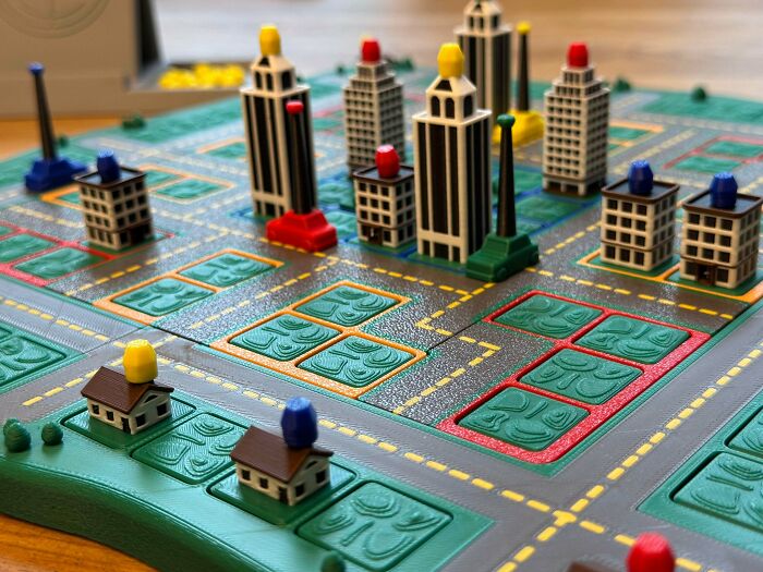A vibrant 3D printed board game city, showing custom pieces people needed and printed with their 3D printers for unique gameplay.