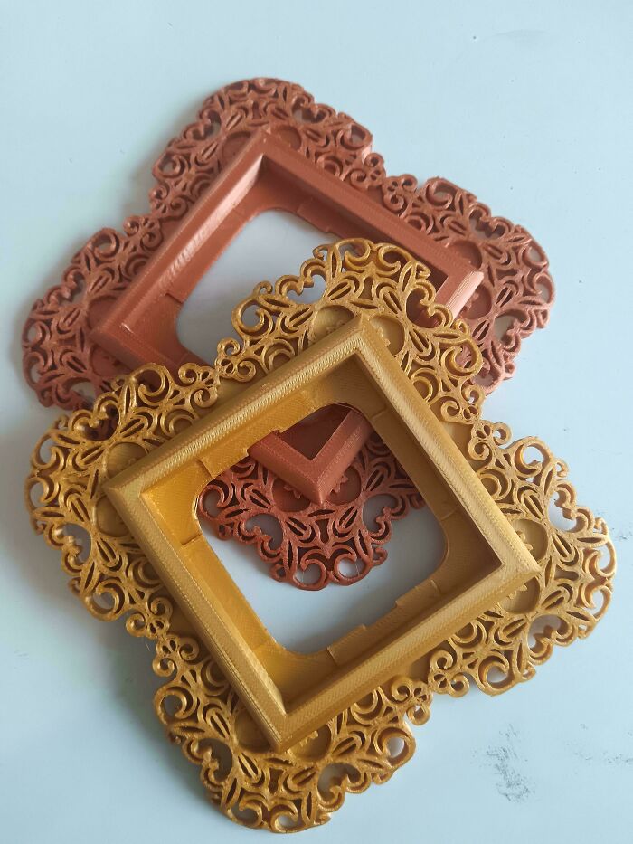 Two ornate, decorative frames in gold and copper, showcasing possibilities with 3D printers.