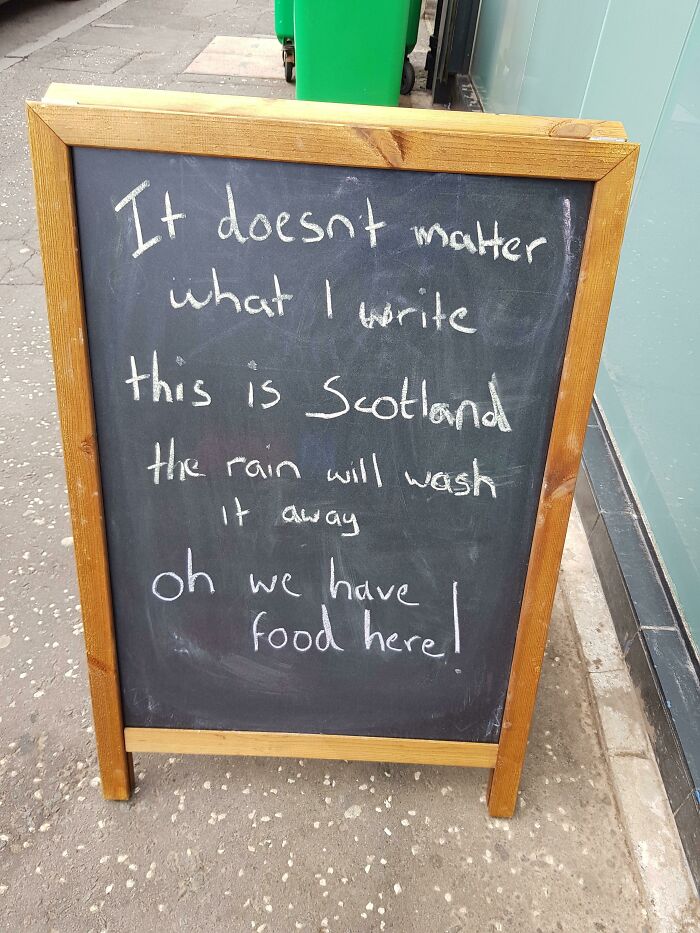 Chaotic sign: A chalkboard in Scotland, humorously stating rain will wash away the writing and they have food here.