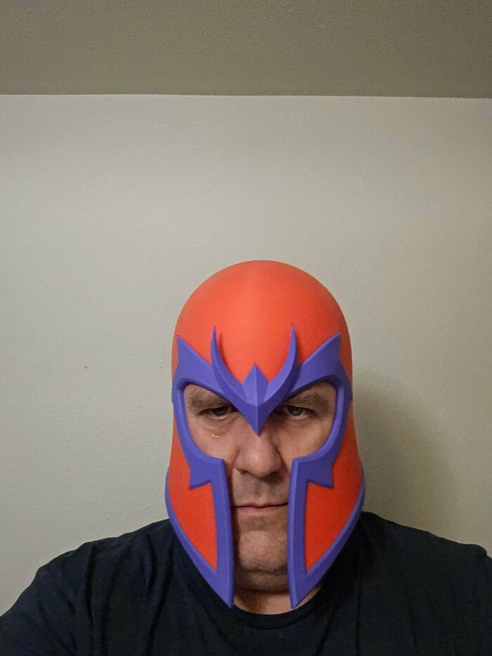 A person wearing a vibrant, custom-made Magneto helmet, demonstrating how people printed unique items with 3D printers.