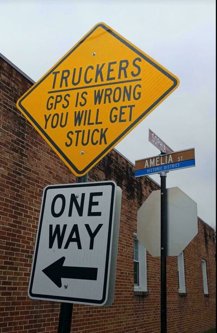 A chaotic sign in the wild warning truckers their GPS is wrong and they will get stuck, making people question reality.
