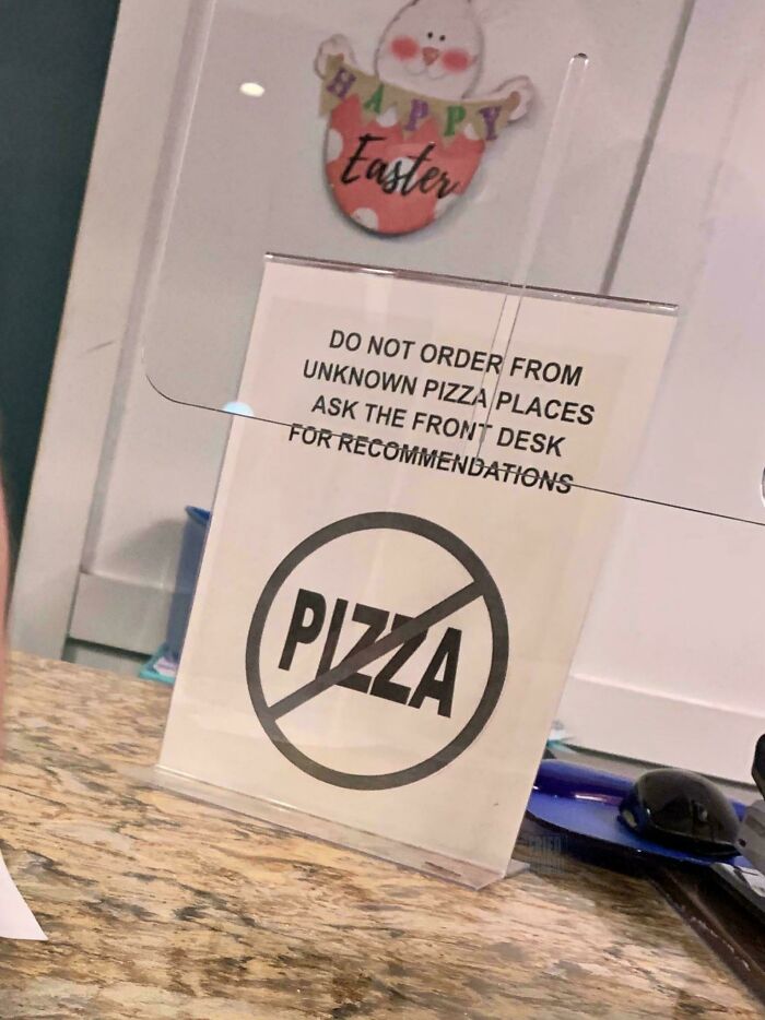 A chaotic sign in the wild prohibiting ordering pizza from unknown places, making people question reality.