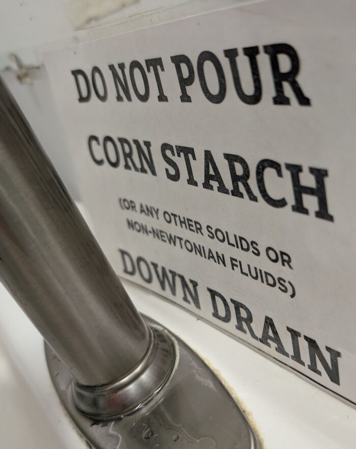 A chaotic sign in the wild that reads DO NOT POUR CORN STARCH (OR ANY OTHER SOLIDS OR NON-NEWTONIAN FLUIDS) DOWN DRAIN.