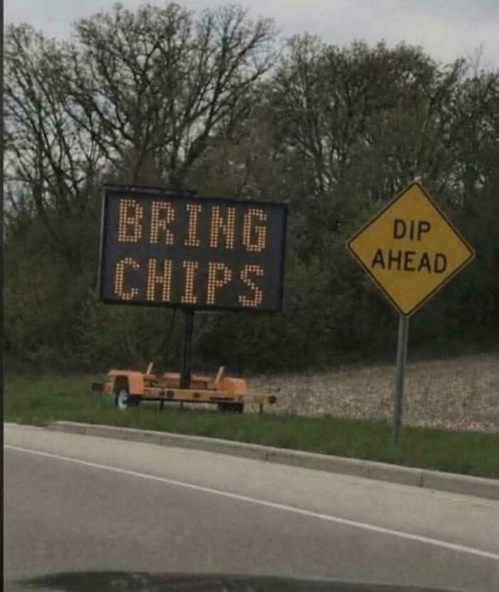 Two chaotic signs in the wild: an electronic road sign says BRING CHIPS, next to a yellow diamond DIPP AHEAD sign.