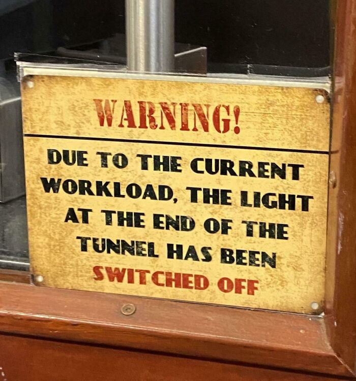 A chaotic warning sign stating the light at the end of the tunnel has been switched off due to workload.