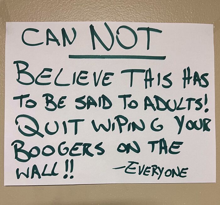 A chaotic handwritten sign telling adults to stop wiping boogers on the wall.