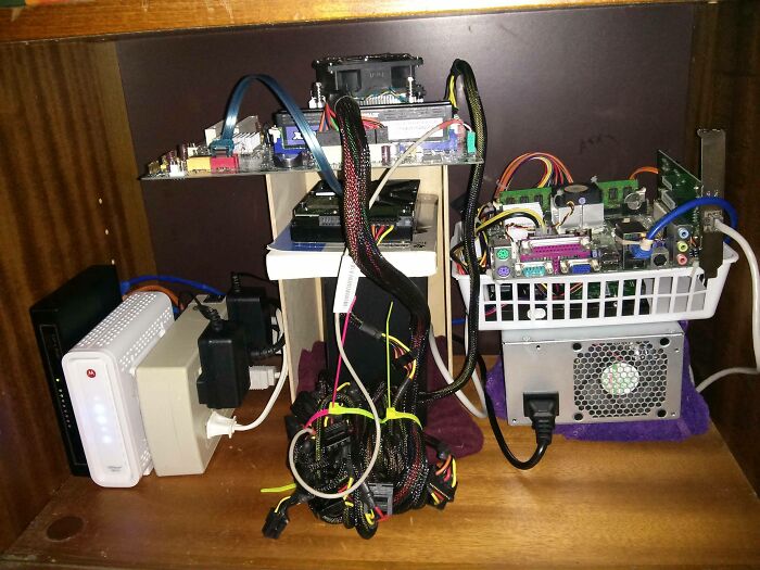 A makeshift computer setup with multiple motherboards and wires, illustrating a DIY fail.