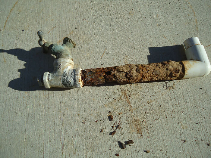 A rusty, corroded pipe with a spigot, showing a DIY fail in plumbing.