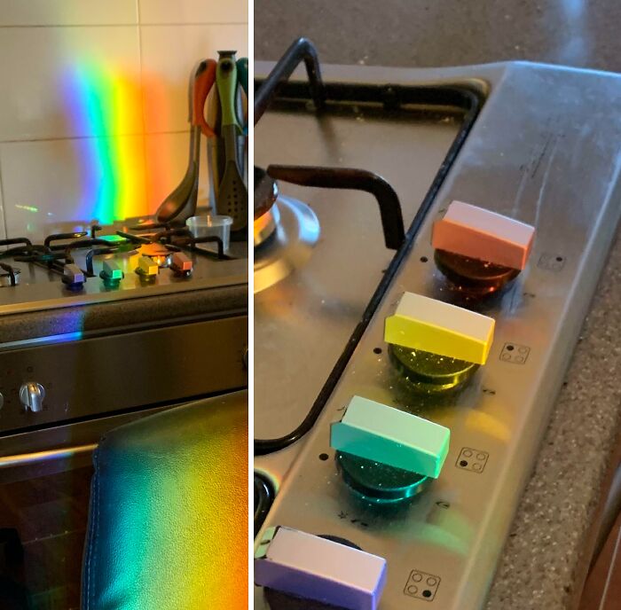 A rainbow light ray perfectly synced and falling across a kitchen stovetop and its knobs.