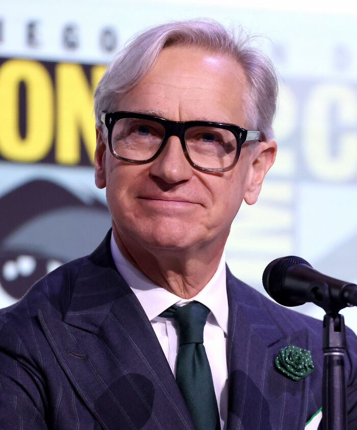 Paul Feig, director and filmmaker, with grey hair and glasses, wearing a pinstripe suit, green tie, and lapel pin.