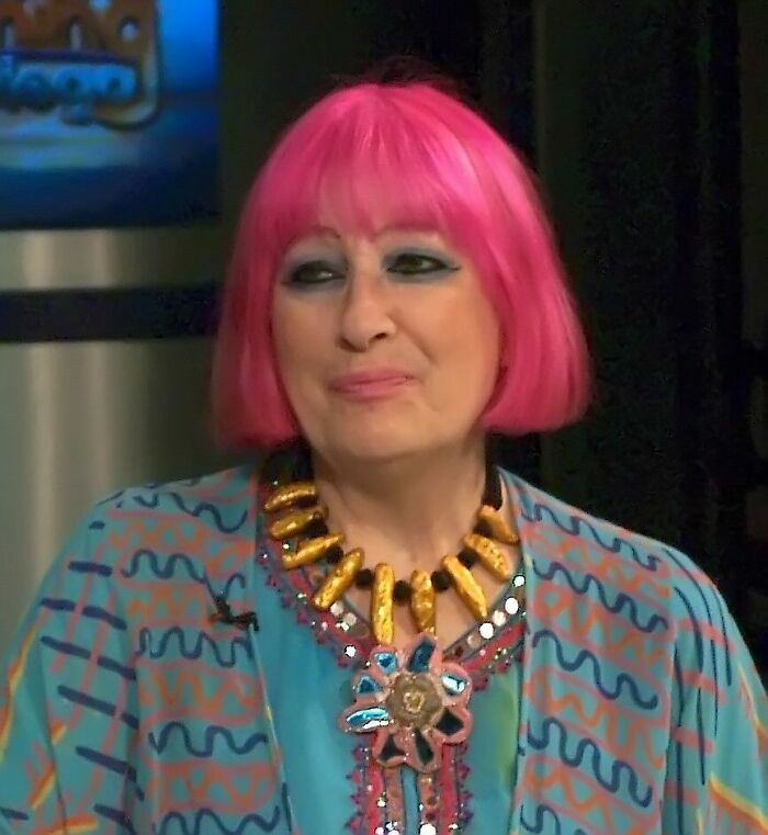 Zandra Rhodes, a renowned fashion designer, known for her vibrant pink hair, bio and career highlights.