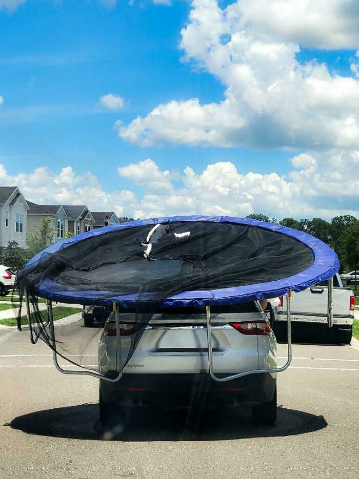 Vehicle carrying an oversized trampoline dangerously protruding, a notable moving fail