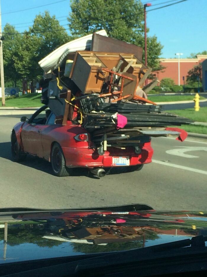 Car overloaded with furniture and household items falling off, a moving fail example