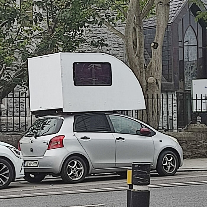 Small car with oversized camper mounted on top shows moving fails