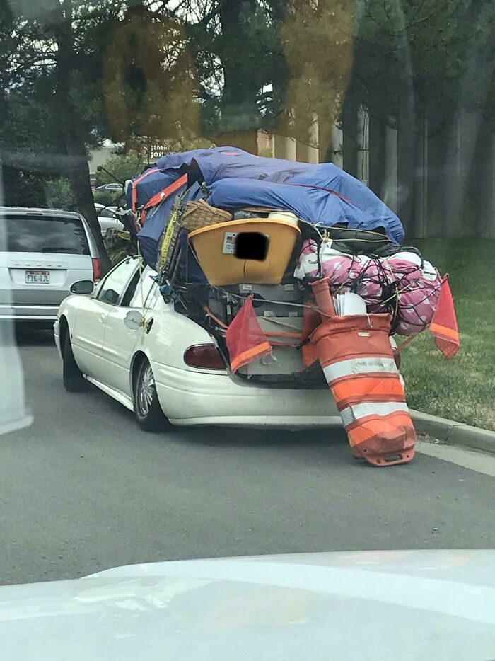 Car overloaded with items and traffic cones moving fails