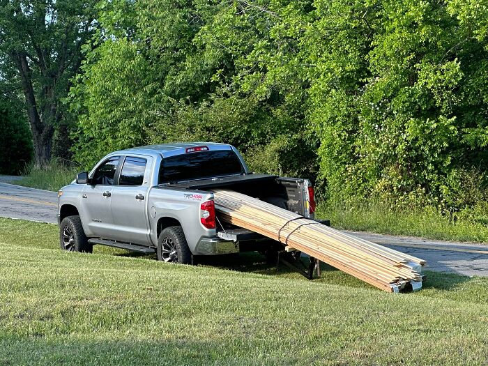 Pickup truck with long wooden planks extending beyond the bed in moving fails pics