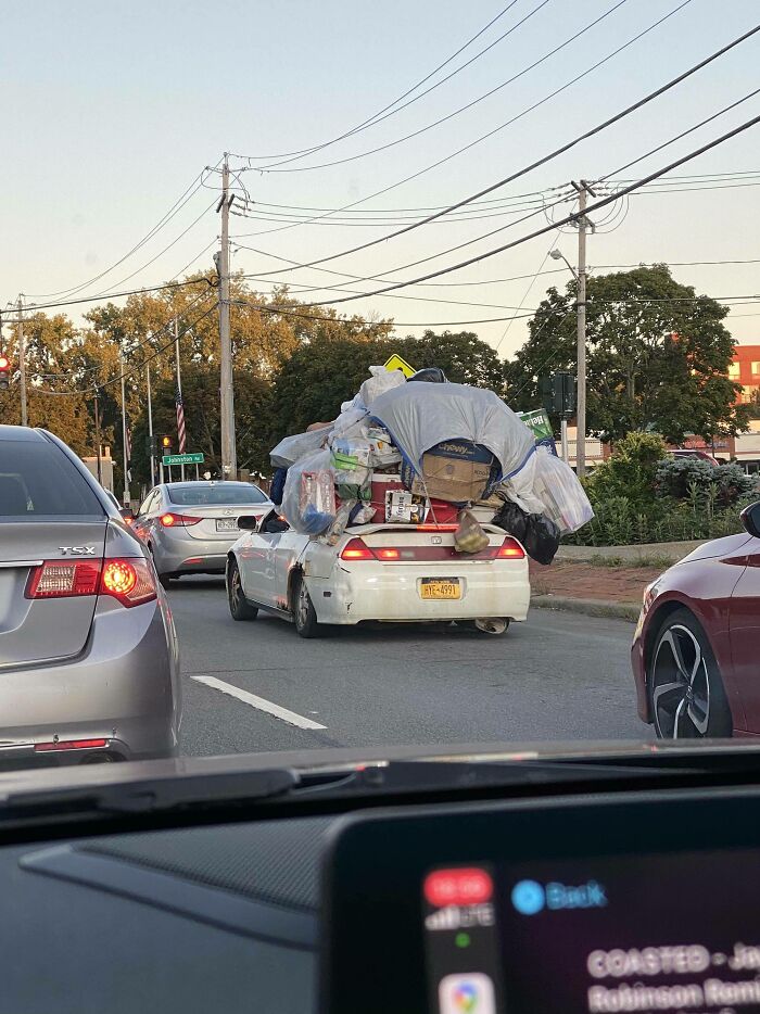 Car overloaded with bulky items stacked high causing a moving fail on the street